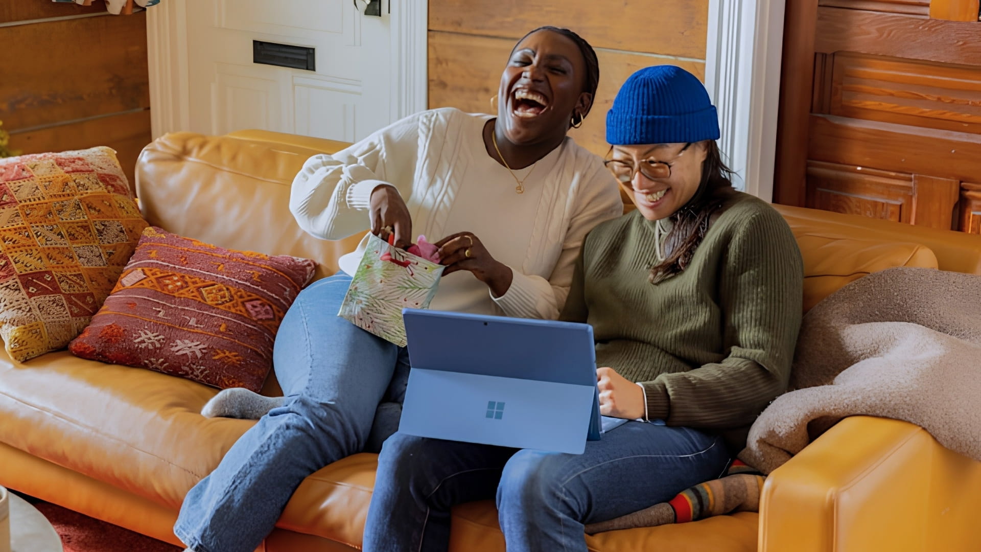 Two housemates laughing at a laptop