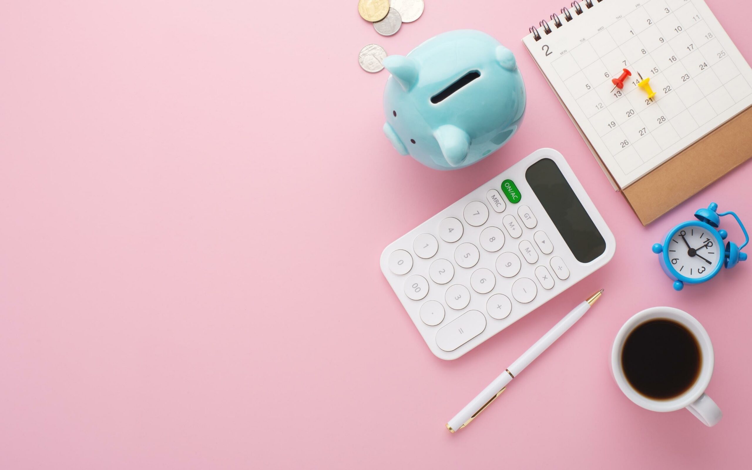 A collection of organiser accessories, including a calculator, mug of coffee, and piggy bank.