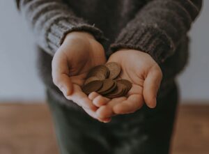 A person holding a handful of coins