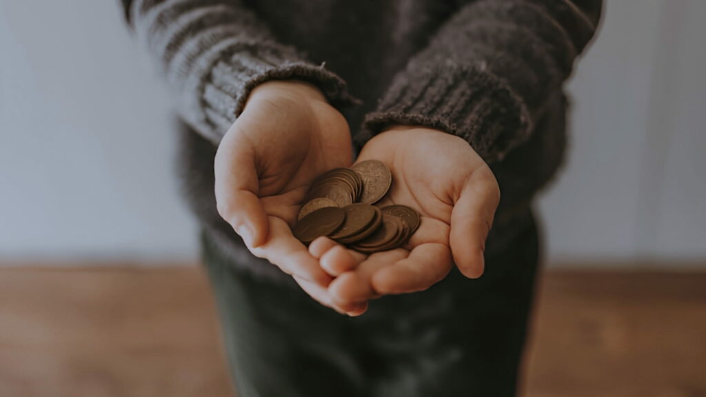 A person holding a handful of coins