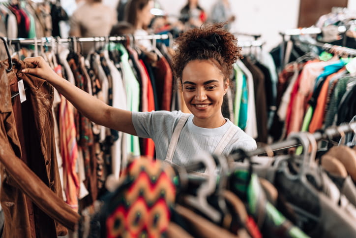 A woman shopping for clothes in a charity shop