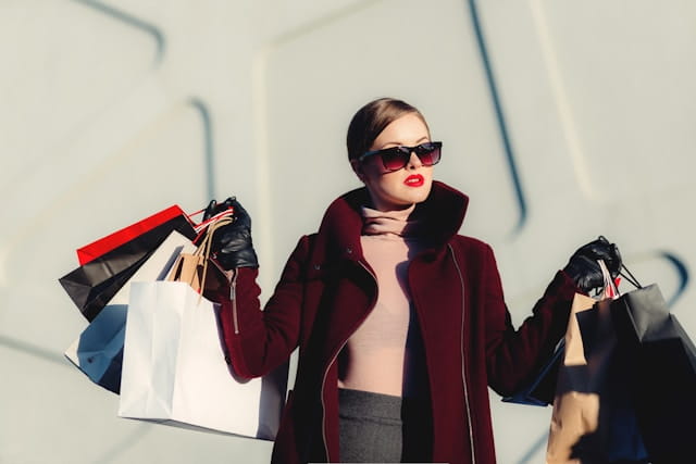 A woman holding multiple shopping bags in each hand
