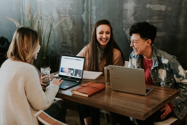 Three young professionals on laptops at a table