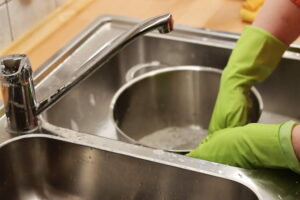A housemate washing up a pan in the sink
