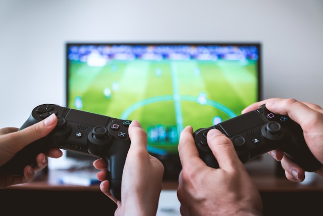 Two gaming controllers in front of a TV